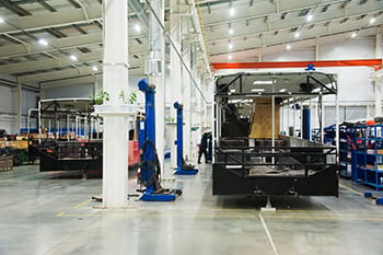 Bus production manufacturing on a warehouse floor.