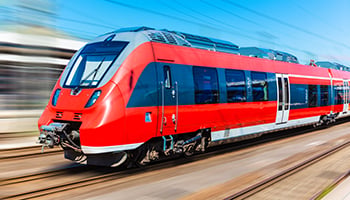 Scenic summer view of modern high speed red passenger commuter train on tracks with motion blur effect