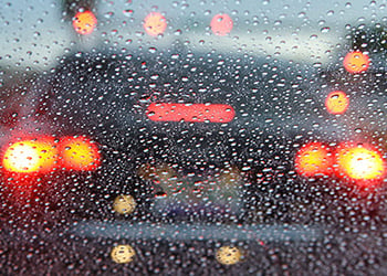 Red brake lights on vehicle in the rain