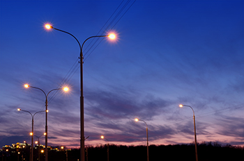 Rows of lit street lamps at night.