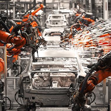 Robotic arms sparking on an automobile production assembly line