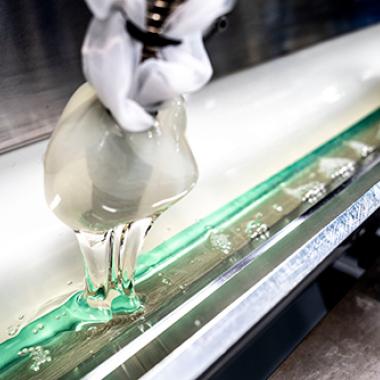 Clear, thick liquid filling a long, stainless steel reservoir piece of equipment.
