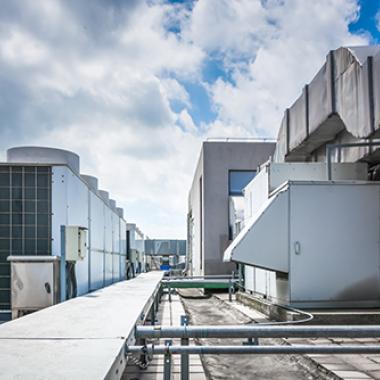 Square air-conditioning unit on the roof with a round fan.