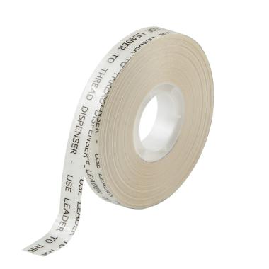A thin spool of white adhesive tape with text on the liner.