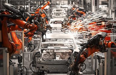 Robotic arms sparking on an automobile production assembly line