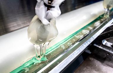 Clear, thick liquid filling a long, stainless steel reservoir piece of equipment.