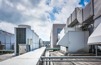 Square air-conditioning unit on the roof with a round fan.