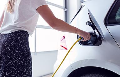 Woman charging an electric car.
