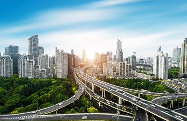 An elevated city overpass featuring skyscrapers and a highway traffic system