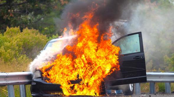 Car on fire near side of road