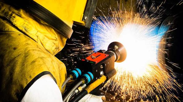 Thermal spray process as technician repairs a shaft by wire arc