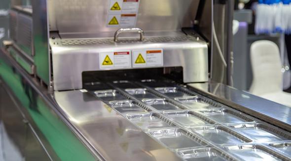 Linear food plastic tray package heat sealing machine in the food industry.