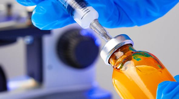 Medical vial with medication and syringe close up.
