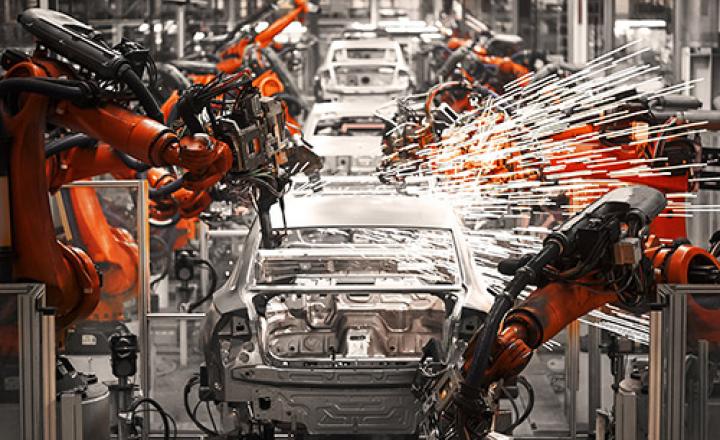 Robotic arms sparking on an automobile production assembly line