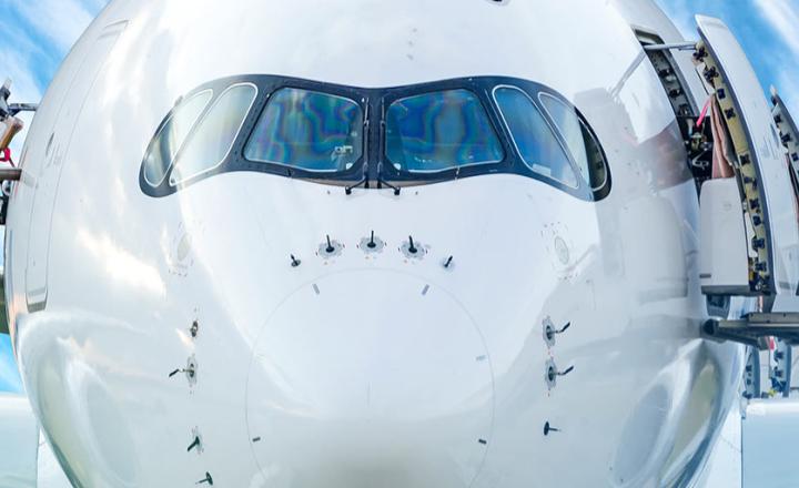 View of the airplane from the cockpit fuselage at sunset in the airport