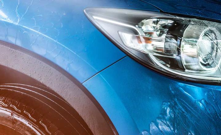Blue compact SUV car with sport and modern design being washed with water