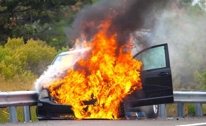 Car on fire near side of road