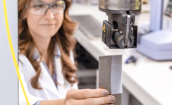 A technician holds a piece of adhesive tape inside a laboratory