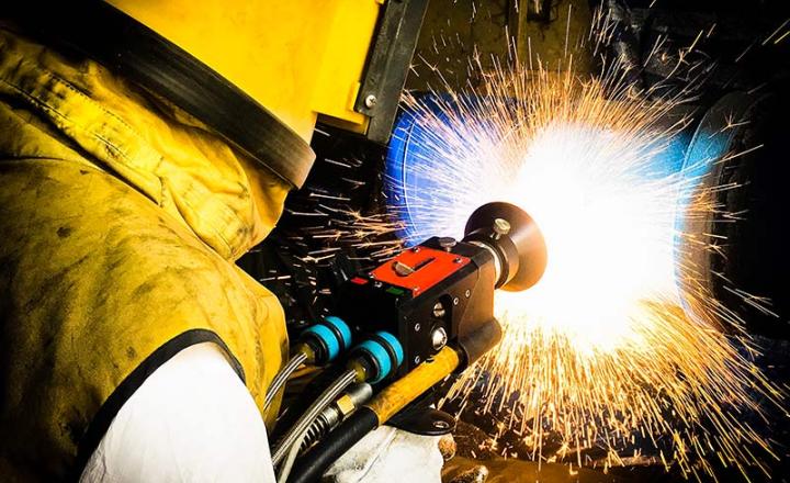 Thermal spray process as technician repairs a shaft by wire arc