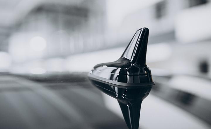 Antenna attached to a black car roof.