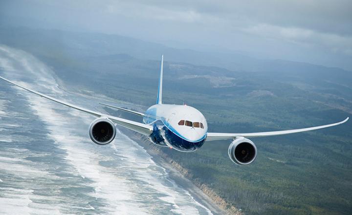 A jet flies over land and sea