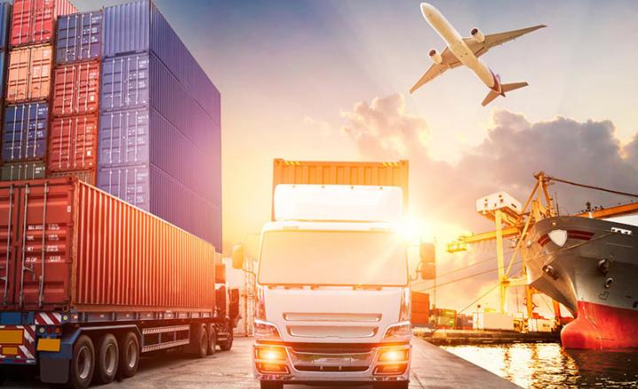 View of a port with containers, trucks, an airplane and a ship.
