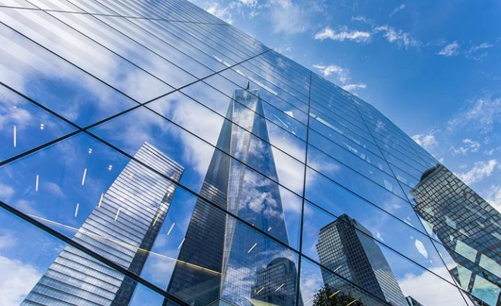 The Freedom Tower in New York City reflected in a mirrored facade of the 9/11 memorial museum