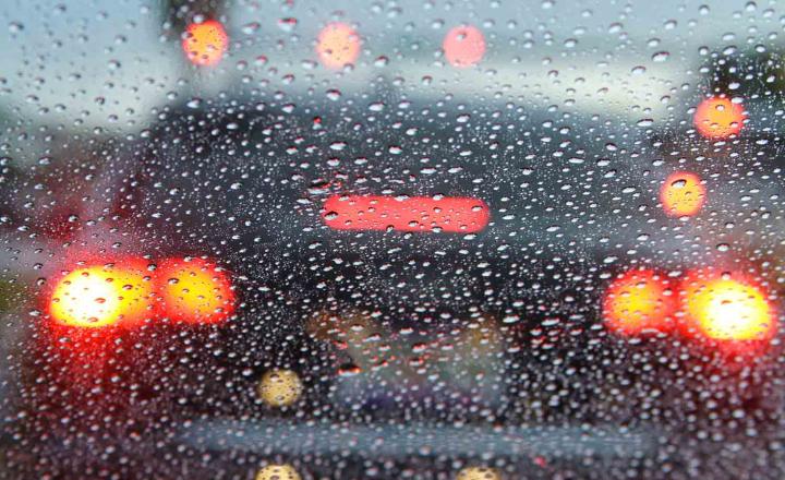 Red brake lights on vehicle in the rain