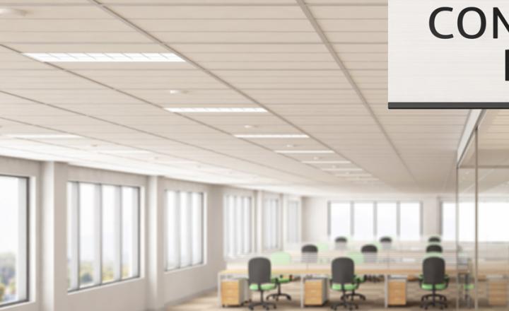 White conference room sign attached to a wall inside of a light and modern office building with meeting areas, glass partitions and windows
