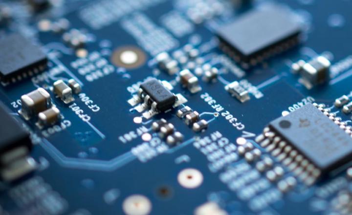Detail of blue electronic microchip circuit board with blurred edges.