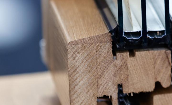 Close-up view of a wooden window frame showing the design of the window and its parts with spacers and isolation between multiple glass layers