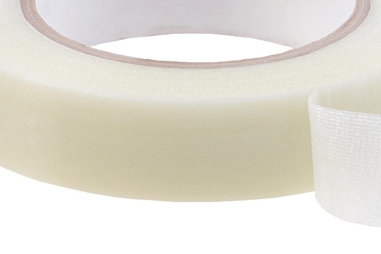 A neutral-colored tape peeled back showing adhesive. A neutral-colored tape peeled back showing adhesive.