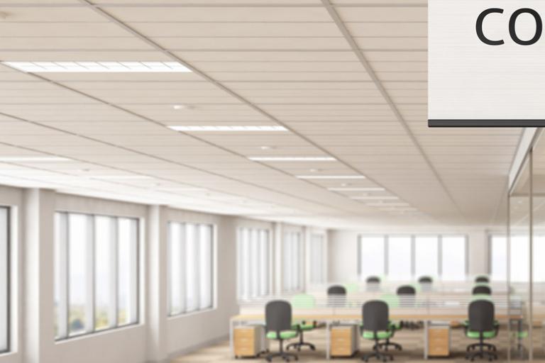 White conference room sign attached to a wall inside of a light and modern office building with meeting areas, glass partitions and windows