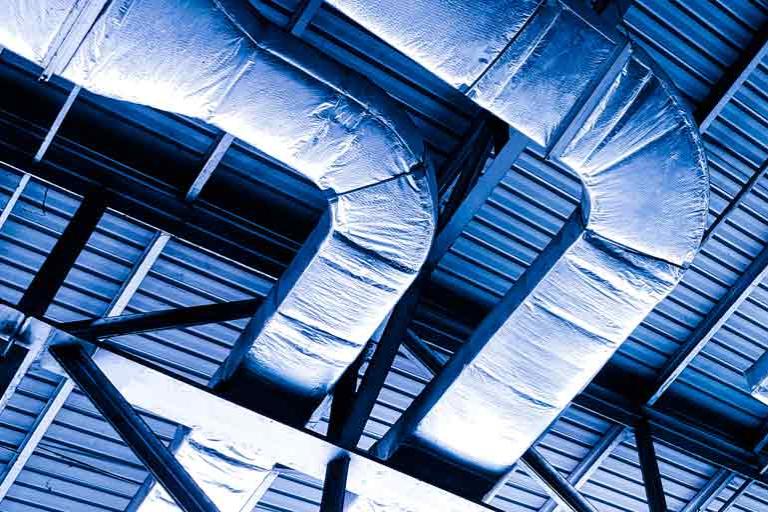 Isolated heating and ventilation lines under the metal ceiling of a building