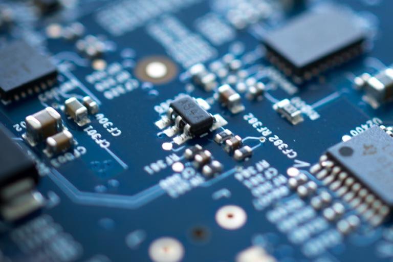 Detail of blue electronic microchip circuit board with blurred edges.