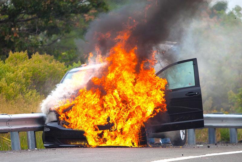 Car on fire near side of road
