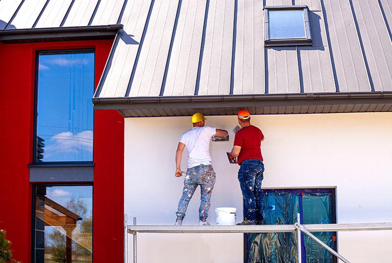 Workers finishing the facade of a modern house
