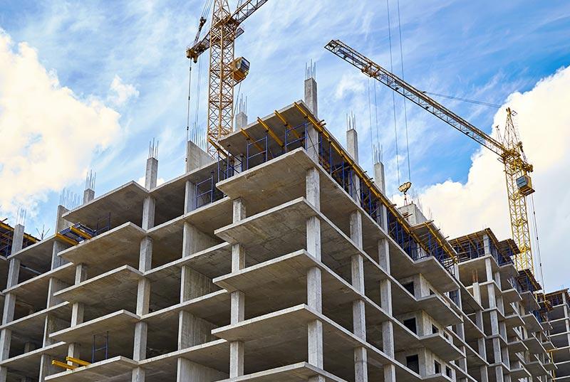 High-rise cranes and concrete walls during construction.