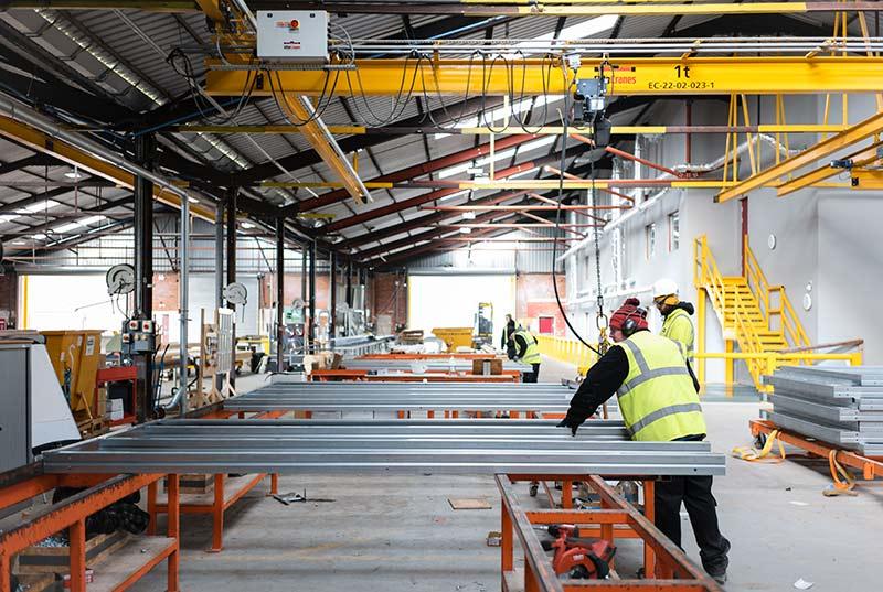 Assembling prefabricated elements inside a manufacturing facility