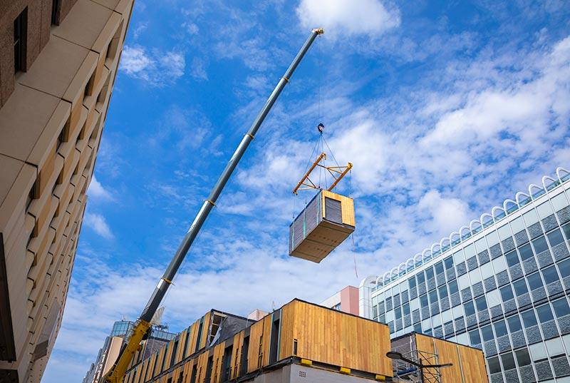 Installation of a modular unit hanging in the air on a construction site