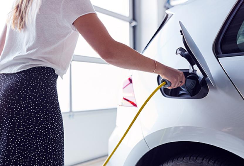 Woman charging an electric car.